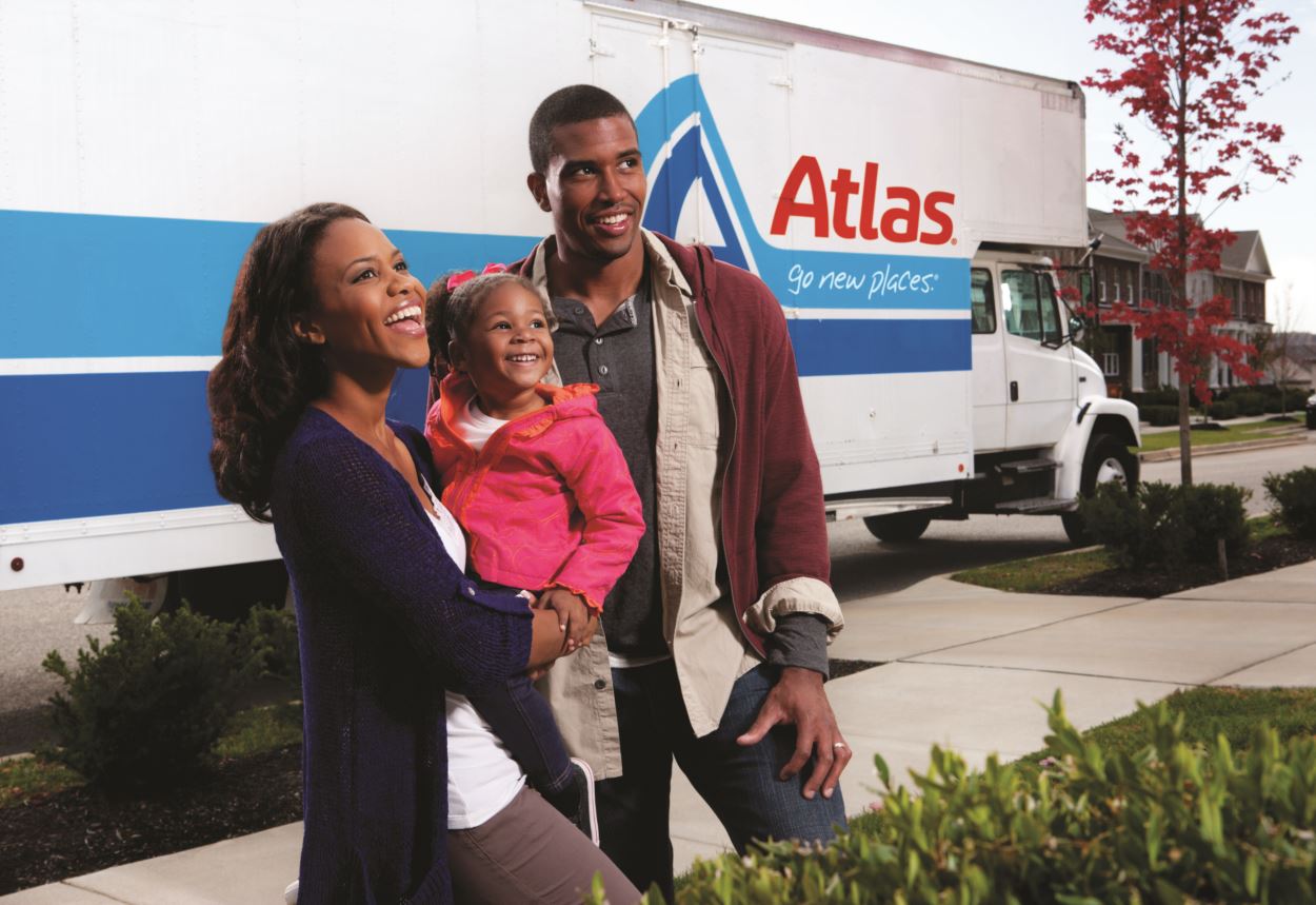 Family with child standing in front of Atlas moving truck